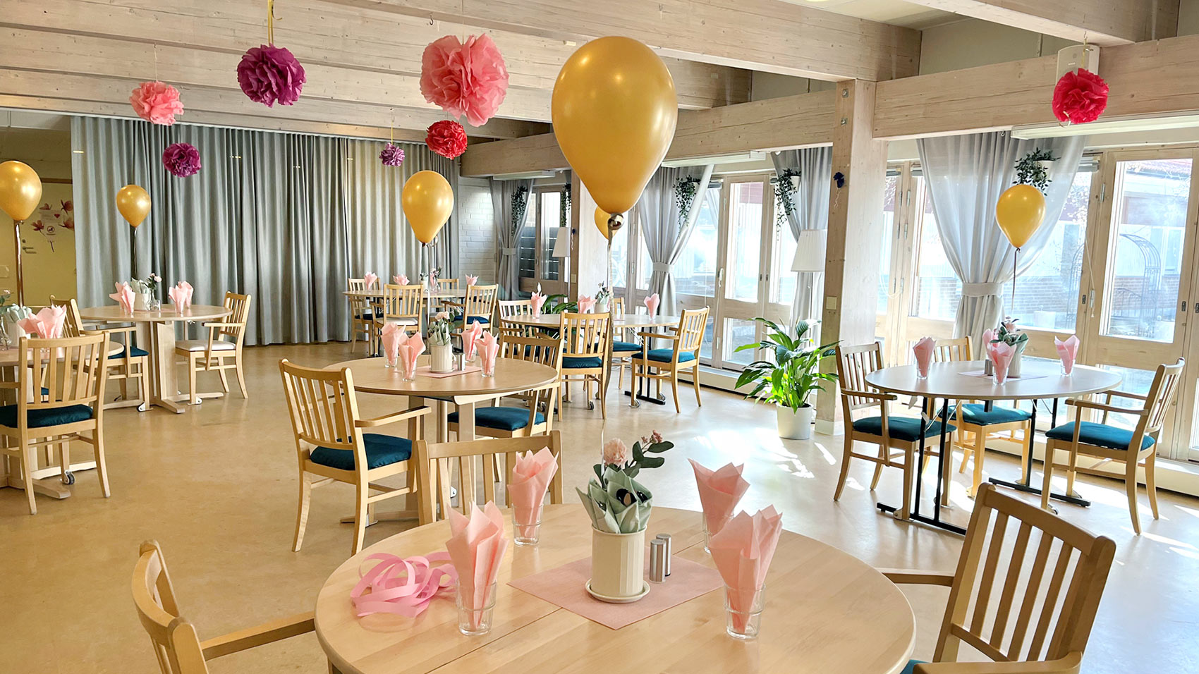 Restaurangmiljö på äldreboende, festligt pyntad med ballonger och servetter