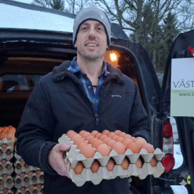 Magnus Fryckberg håller i ett flak med ljusbruna ägg