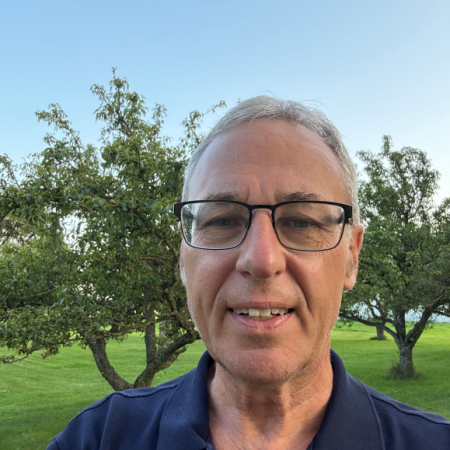 Mats Pettersson har mörkblå tröja och står utomhus en solig dag