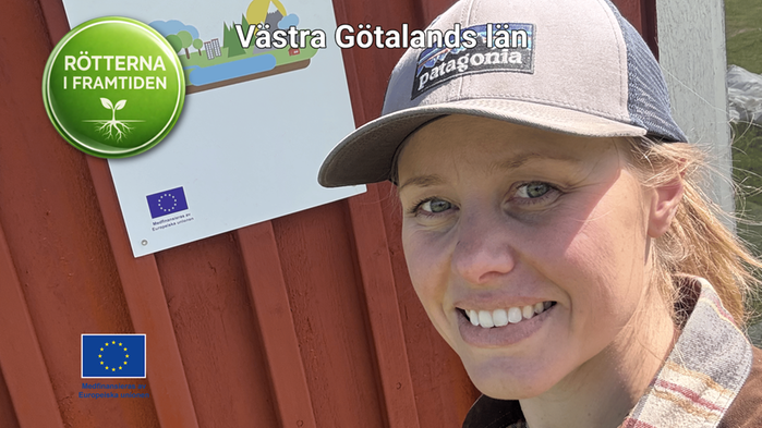 Johanna Wiberg i keps står vid en röd ladugård
