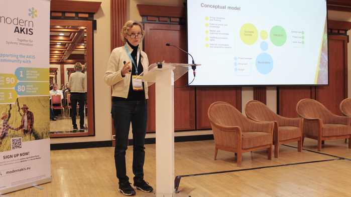 Lisa Blix Germundsson på scen med en skärm i bakgrunden