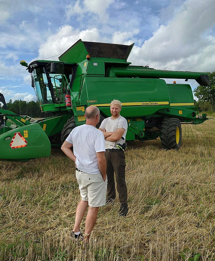 Nils vid sin stora gröna traktor på fältet