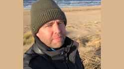 Henrik Roos projektledare för EU-projektet BioGov står vid vatten med grön mössa och svart jacka