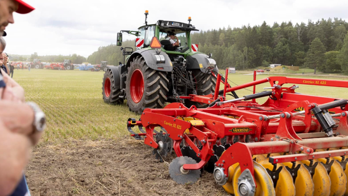 En röd traktor plöjer på Brunnby lantbrukardagar