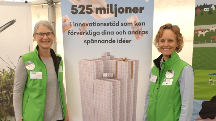 Ragni Andersson och Lisa Blix Germundsson i ett mässtält framför en roll-up med information om innovationsstödet EIP-Agri