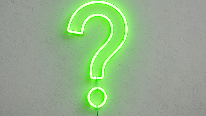 Ett frågetecken i grön neon på vit vägg