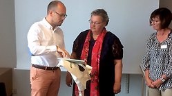 David Font överlämnar en barnbok om hur det är att vara flykting till Åsa Karlsson och Susanne Andersson. Foto: Hans-Olof Stålgren.